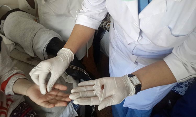 The first patient takes the very first dose of Bedaquiline in Almaty, Kazakhstan. (Photo by Yekaterina Sahabutdinova / Partners In Health)