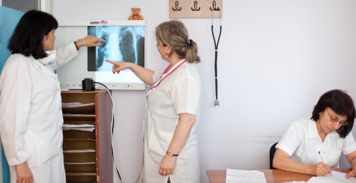 ექიმი იზა ჯიქია (მარცხნივ) და ნინი ძიძიკაშვილი (ცენტრში) ამოწმებენ პაციენტის რენტგენის სურათს ტუბერკულოზის ეროვნულ ცენტრში, თბილისში. ახალი მედიკამენტები პაციენტებს უფრო ოპტიმისტურ განწყობას უქმნიან რეზისტენტული ტუბერკულოზის მკურნალობის მხრივ „რა თქმა უნდა პაციენტები უფრო დიდ იმედებს ამყარებენ ახალ მედიკამენტებზე, ვიდრე იმ მედიკამენტებზე, რომლებსაც ისინი წინა მკურნლობის დროს ღებულობდნენ, ახალი წამლებით ისინი უკეთეს შედეგებს აღწევენ“) ამბობს იზა ექიმი.